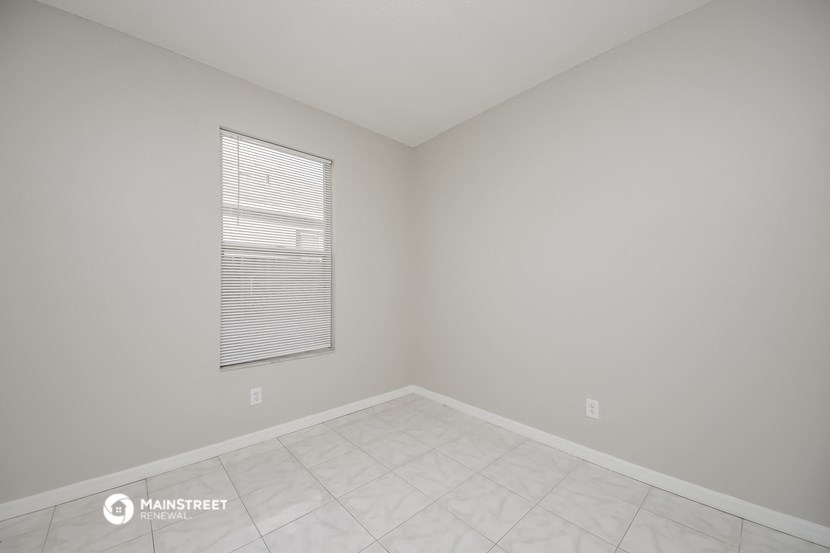 an empty room with a window and a tiled floor