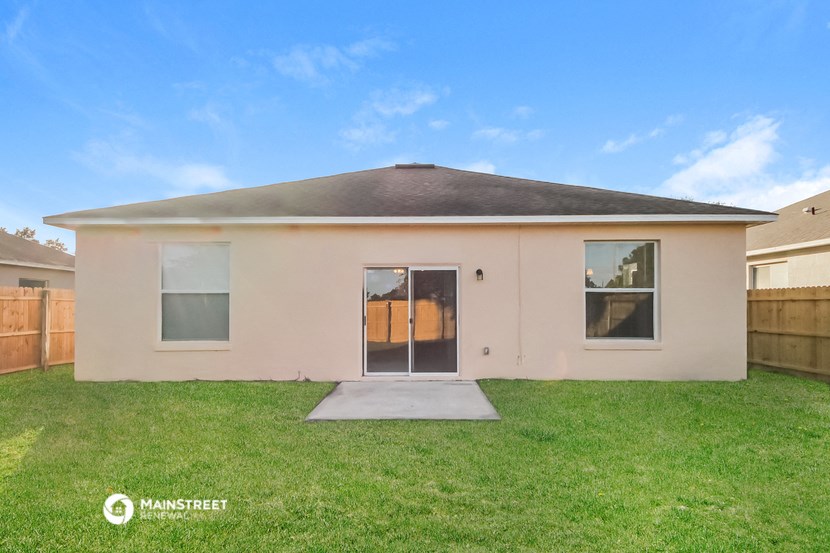 a small beige house with a yard in front of it