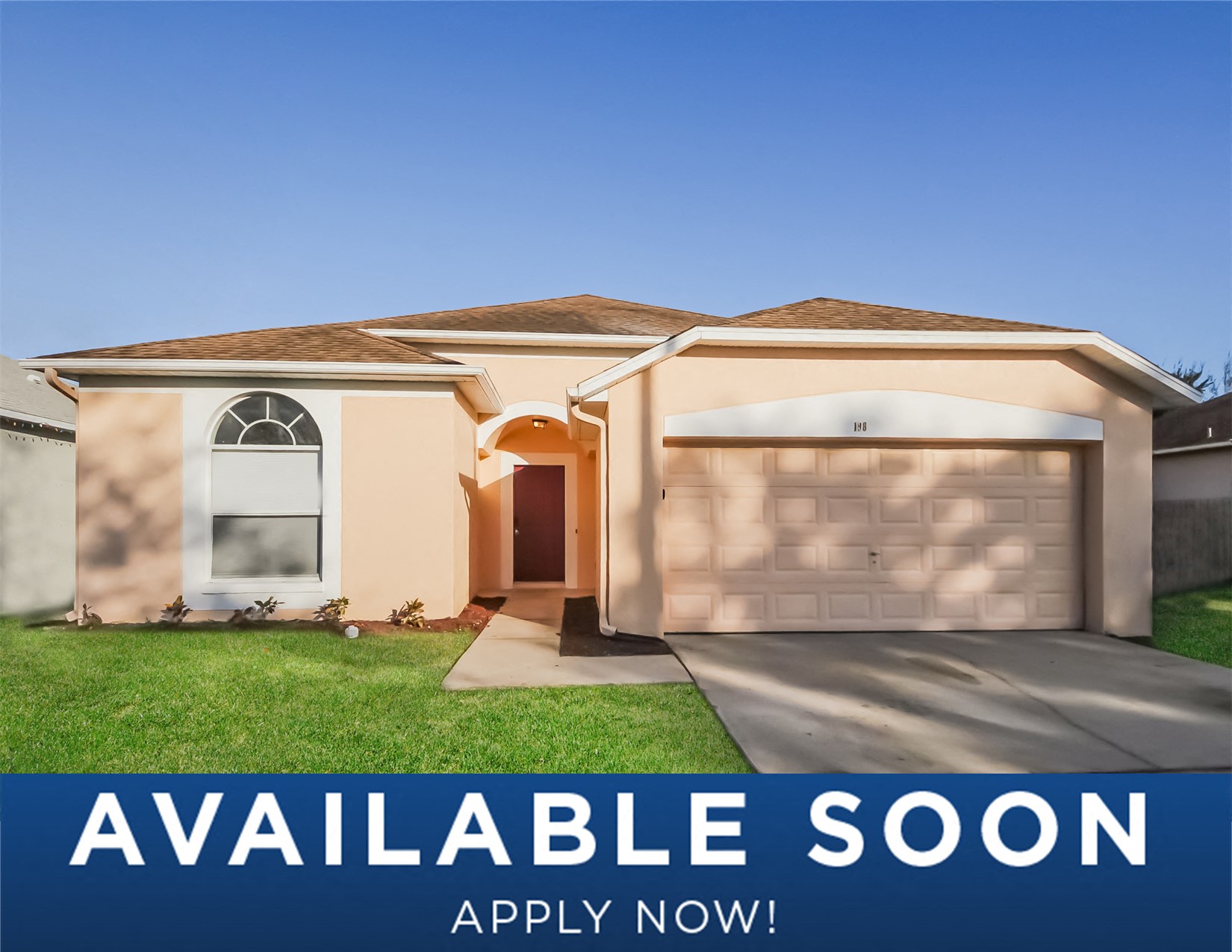 a beige house with a garage door and a lawn