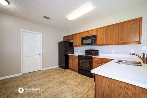 a kitchen with black appliances and wooden cabinets