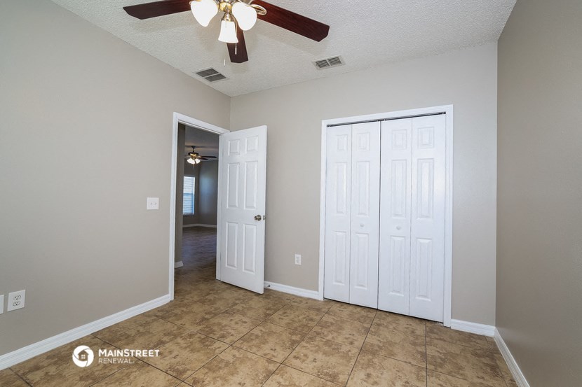 a living room with two closets and a ceiling fan