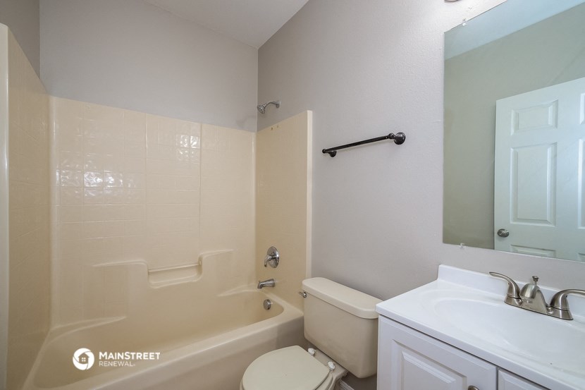 a bathroom with a toilet and a tub and a sink