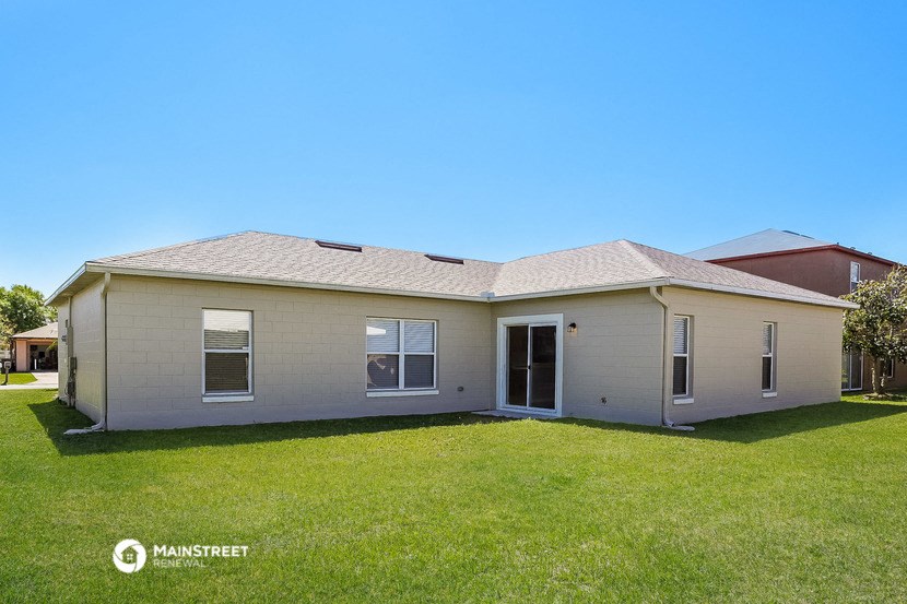 a white house with a grassy yard and a blue sky