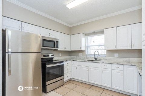 a kitchen with white cabinets and stainless steel appliances