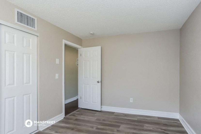 a bedroom with two doors and a door to a closet