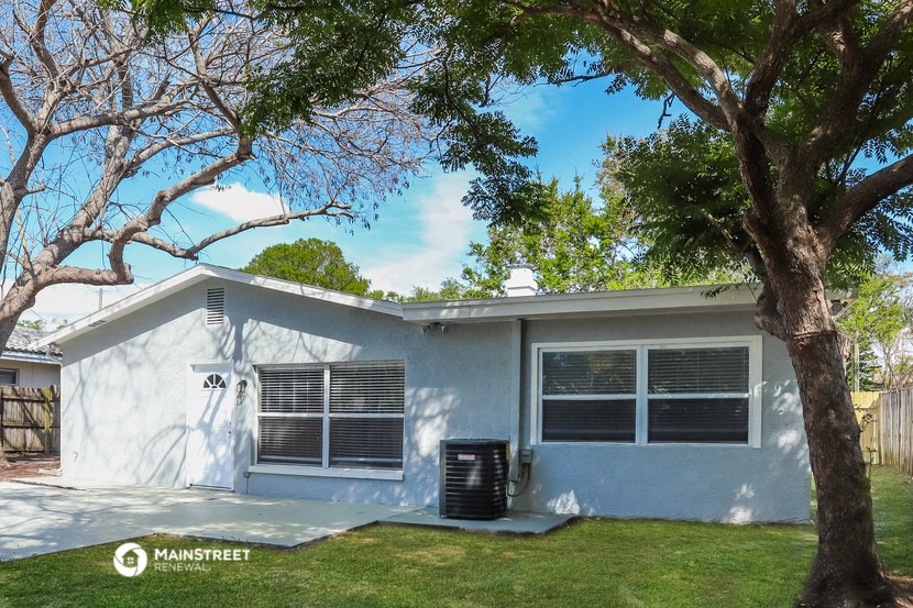 a white house with a tree in front of it