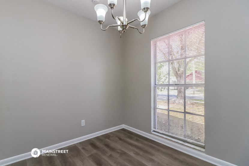 a bedroom with a large window and a chandelier