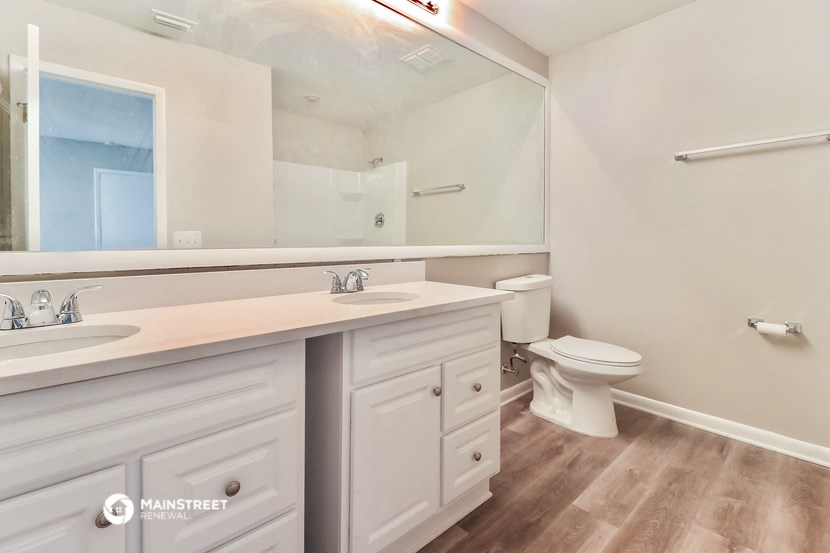 a bathroom with a large mirror and a toilet and sink