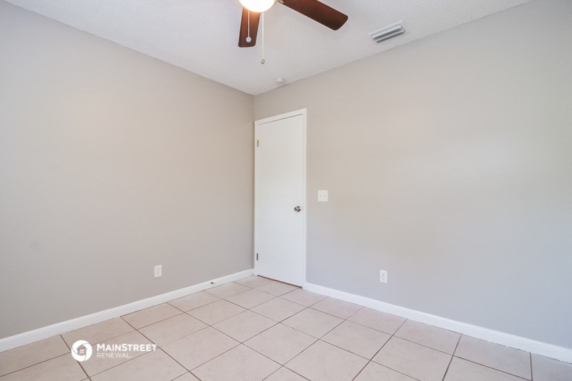 the living room of an empty house with a ceiling fan