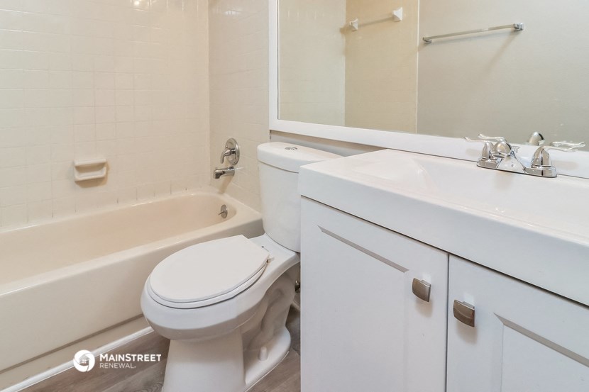 a bathroom with a toilet and a sink and a bath tub