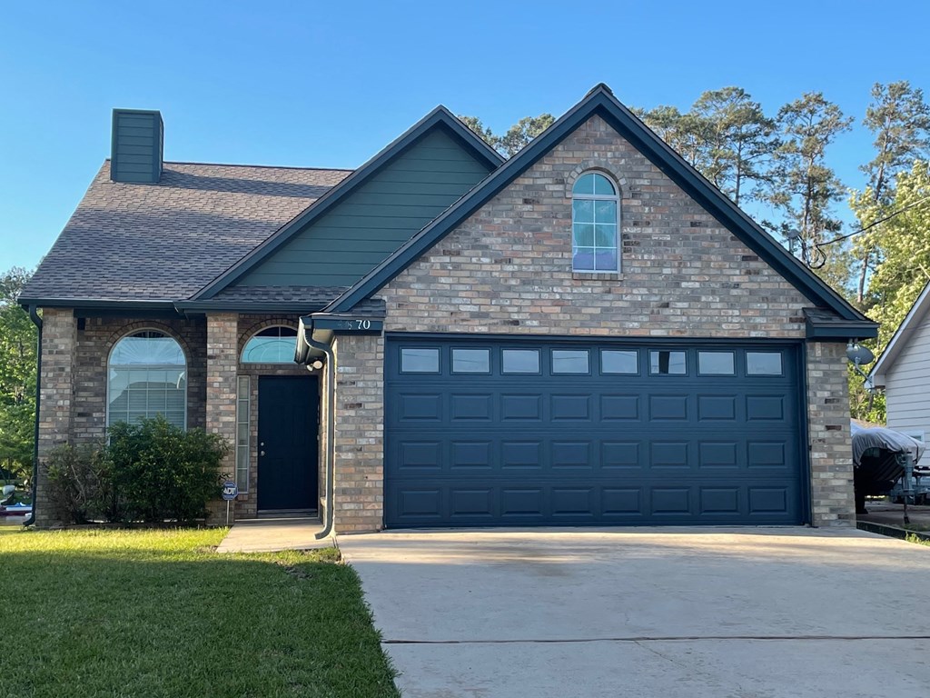 a brick house with a black garage door