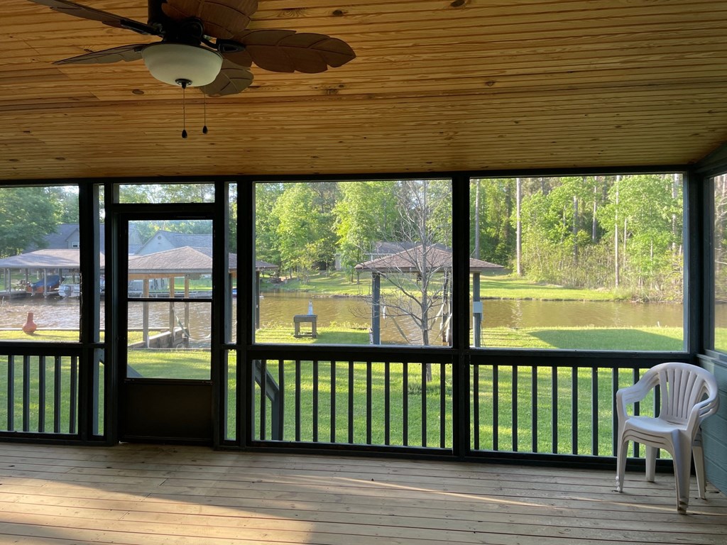 a screened in porch with a view of a pond and a lake