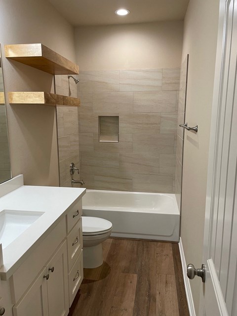 A white bathroom with a toilet, sink, and bathtub.