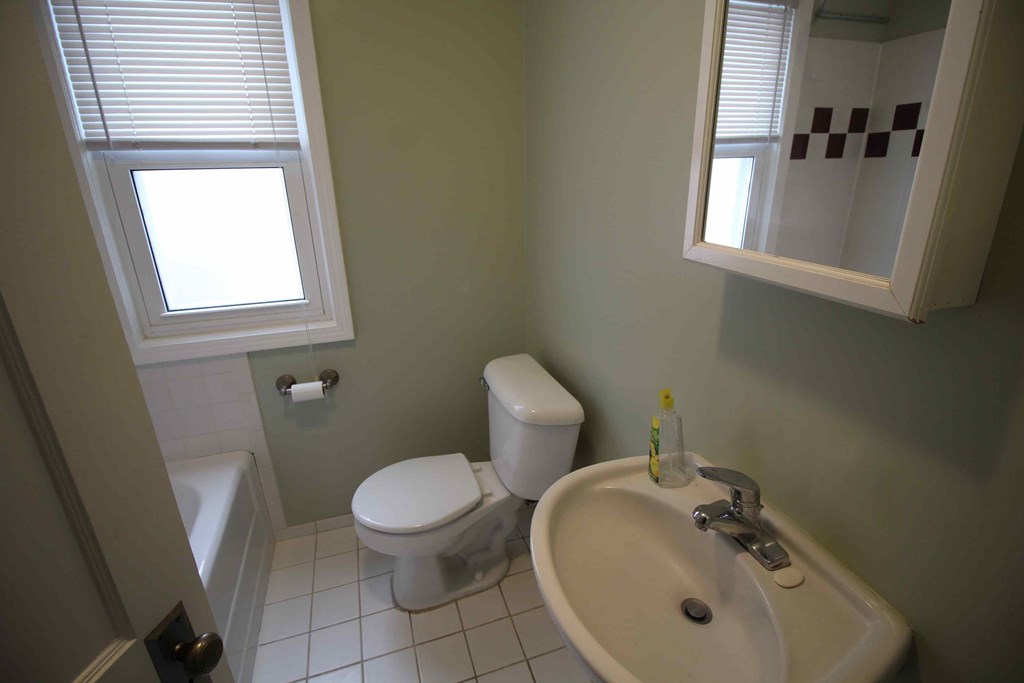a bathroom with a toilet and a sink and a window
