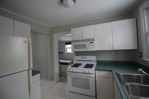 a kitchen with white appliances and white cabinets