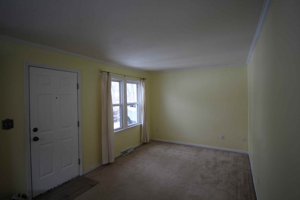 a room with yellow walls and a white door and window