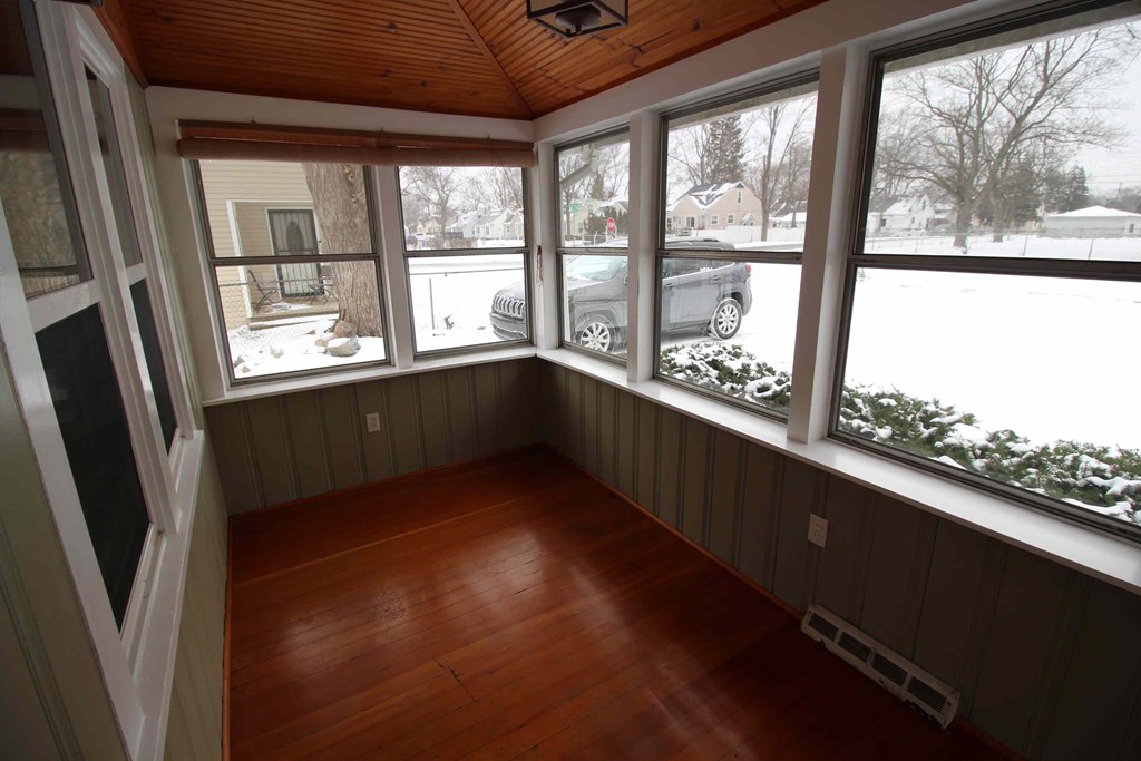 a room with a wood floor and large windows