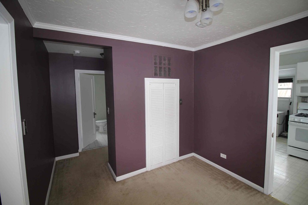 an empty room with purple walls and a white door
