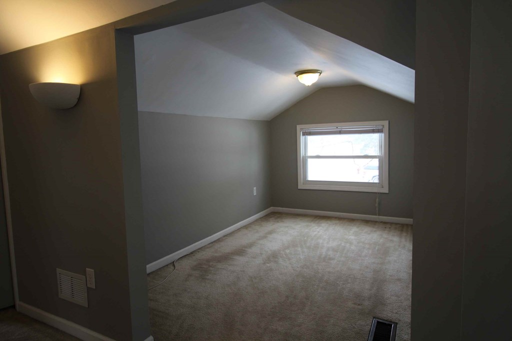 a room with a window and a carpeted floor