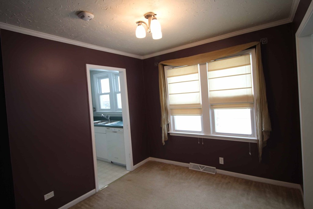 a dining room with brown walls and a window