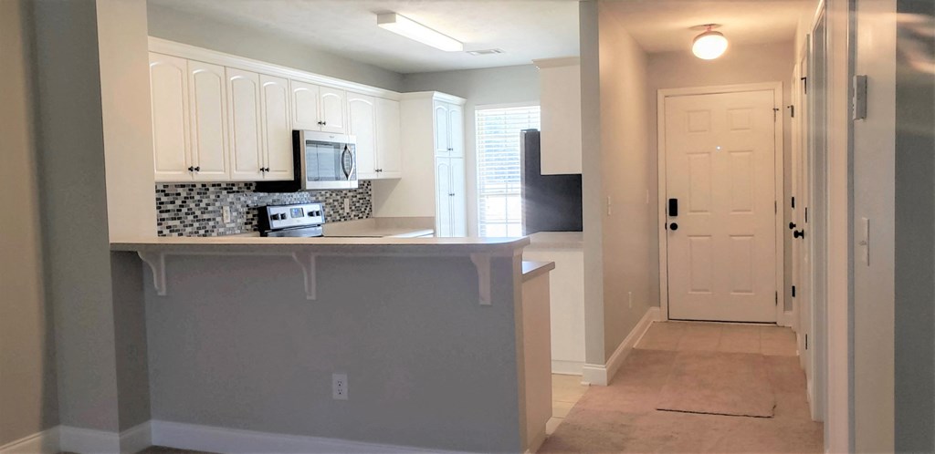 a kitchen with a counter and a door to a hallway