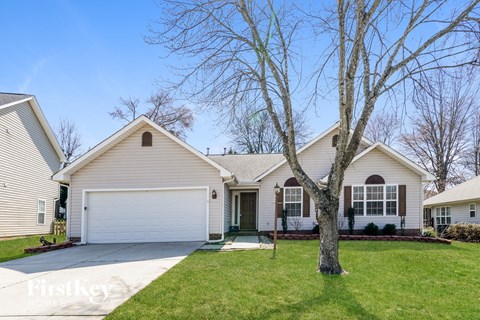 a white house with a tree in the front yard