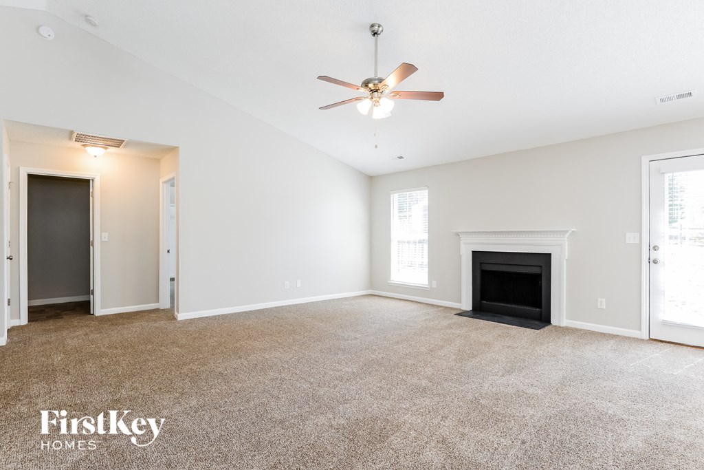 a living room with a fireplace and a ceiling fan