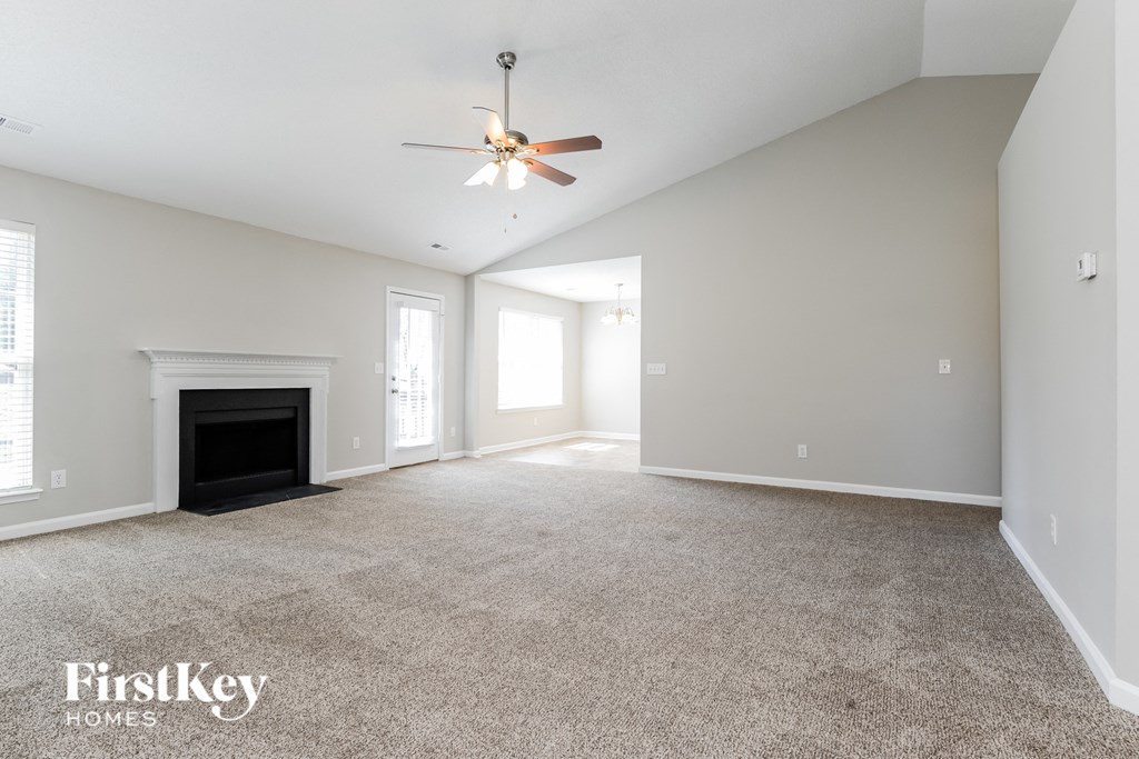 the living room with fireplace and ceiling fan