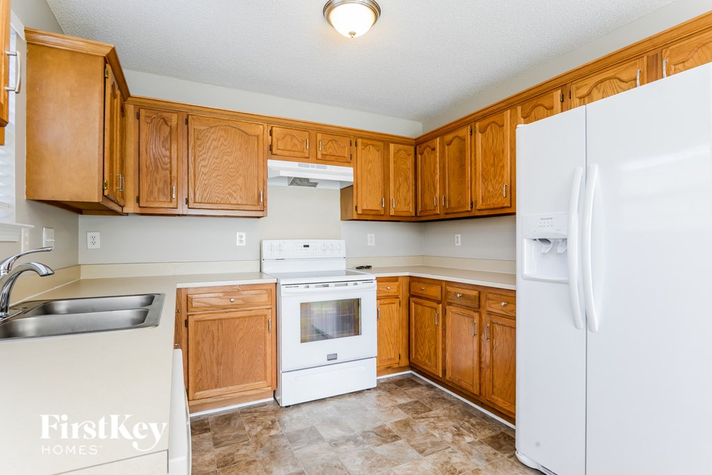 a kitchen with wooden cabinets and white appliances