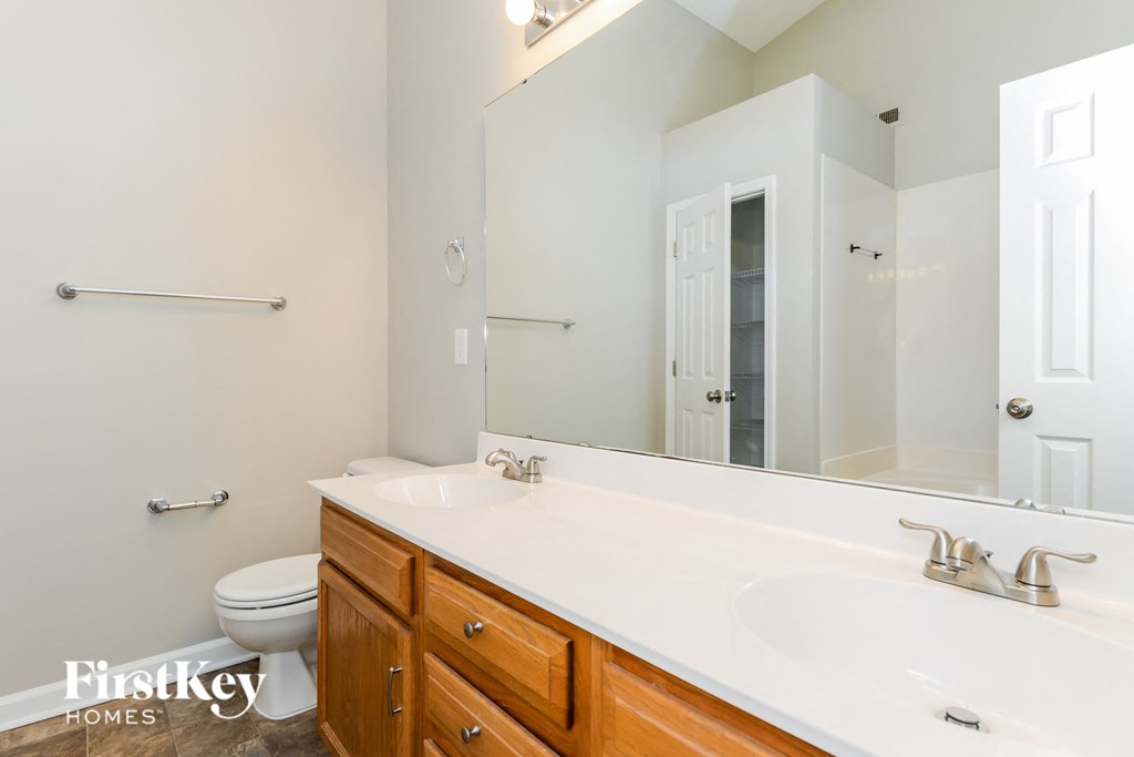a bathroom with a large mirror and a sink and a toilet