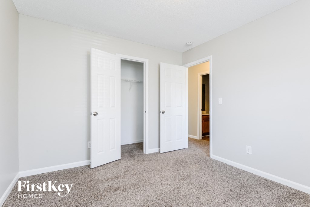 a bedroom with two closets and a carpeted floor