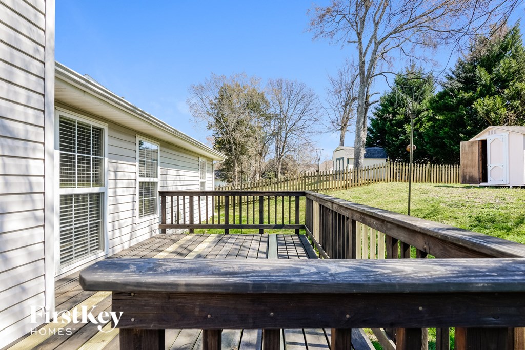 a backyard deck with a fence and a house