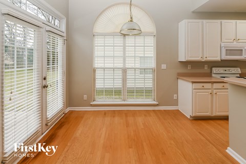 A kitchen with wooden floors and white cabinets.