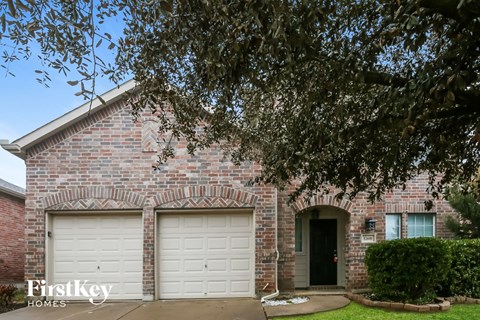a brick house with two white garage doors