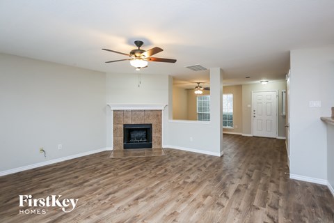 a living room with a fireplace and a ceiling fan