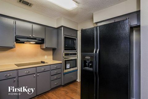 a kitchen with stainless steel appliances and a black refrigerator