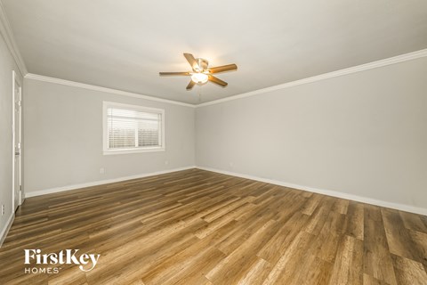the living room of a home with wood floors and a ceiling fan