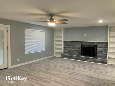 a living room with a fireplace and a ceiling fan