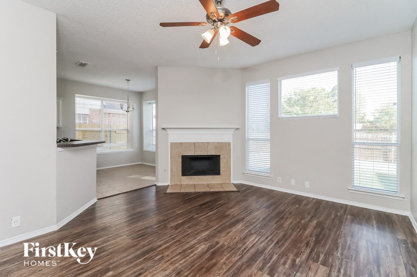 a living room with a fireplace and a ceiling fan