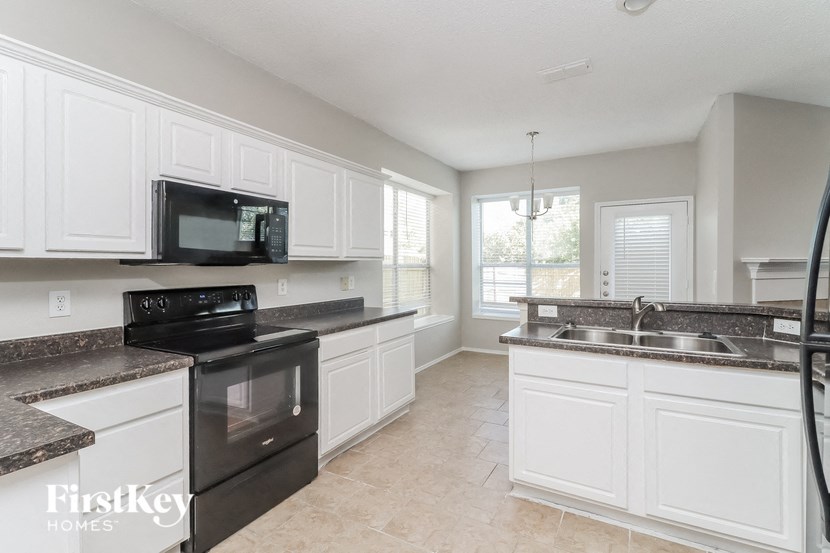 a large kitchen with black appliances and white cabinets