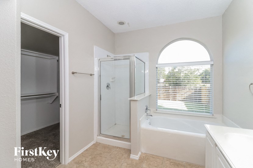 a bathroom with a tub and a shower and a sink