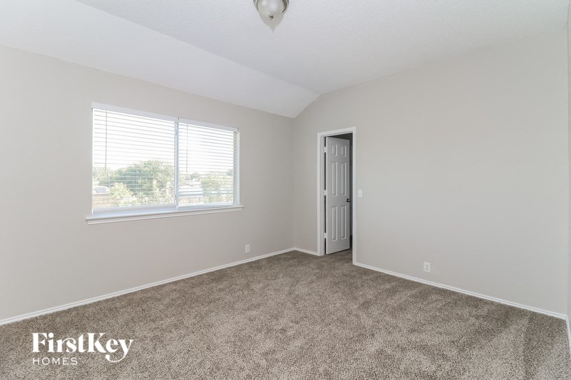 a bedroom with carpet and a window and a door