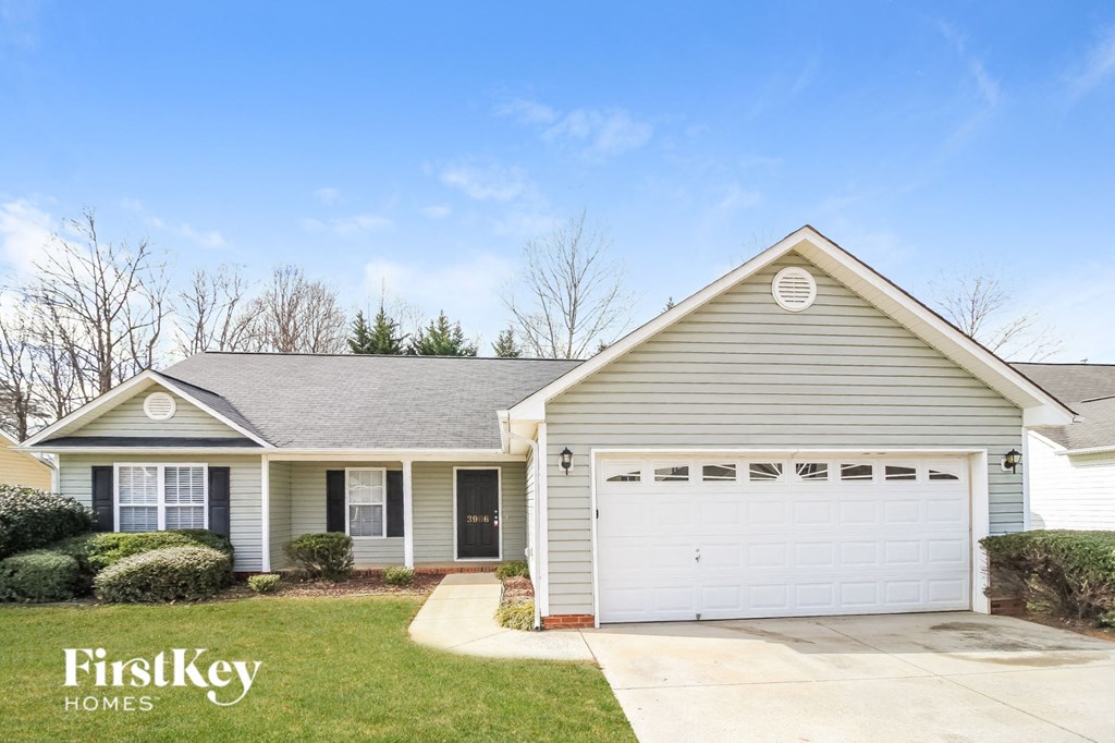 A house with a garage and a driveway in front of it.
