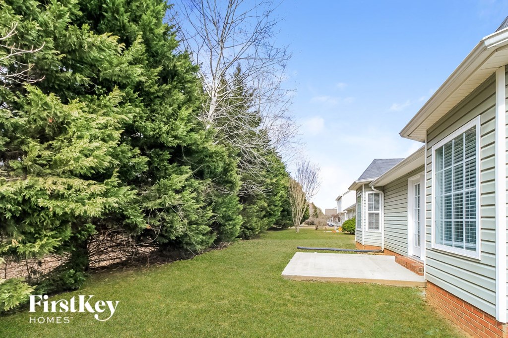 A house with a lawn and trees in the background.