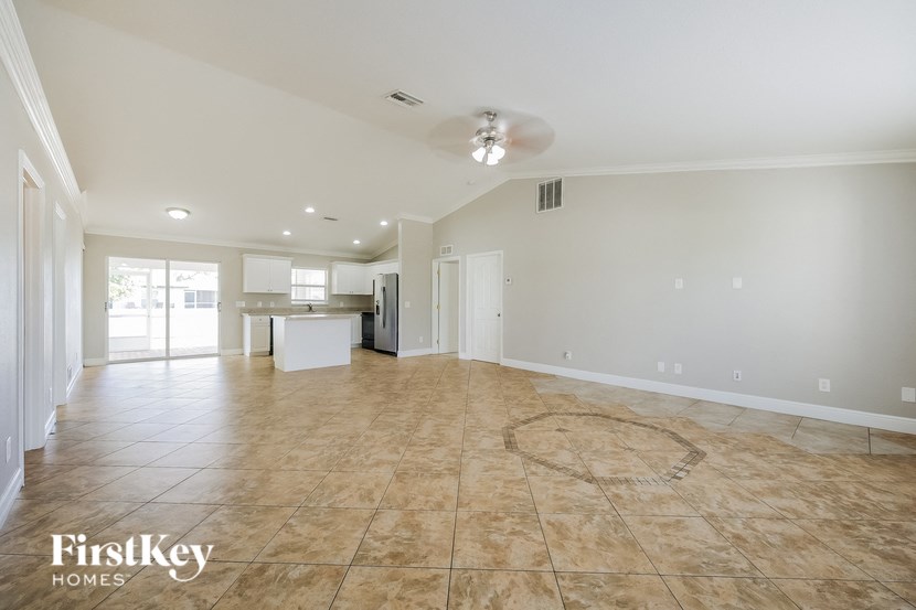 A spacious empty room with a FirstKey Homes logo on the floor.