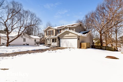 a house in the snow with a garage door