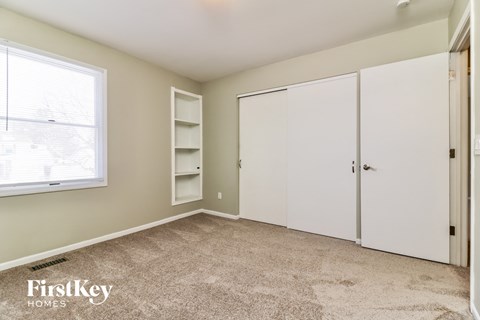 a bedroom with two white closets and a window