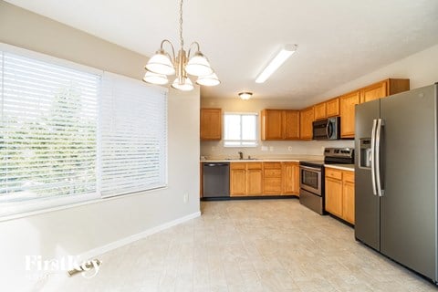 a kitchen with wood cabinets and stainless steel appliances and a large window