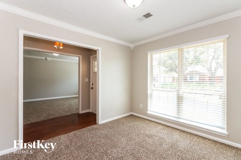 a living room with a large window and a door to a hallway