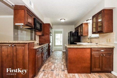 a kitchen with wooden cabinets and a counter top and a sink